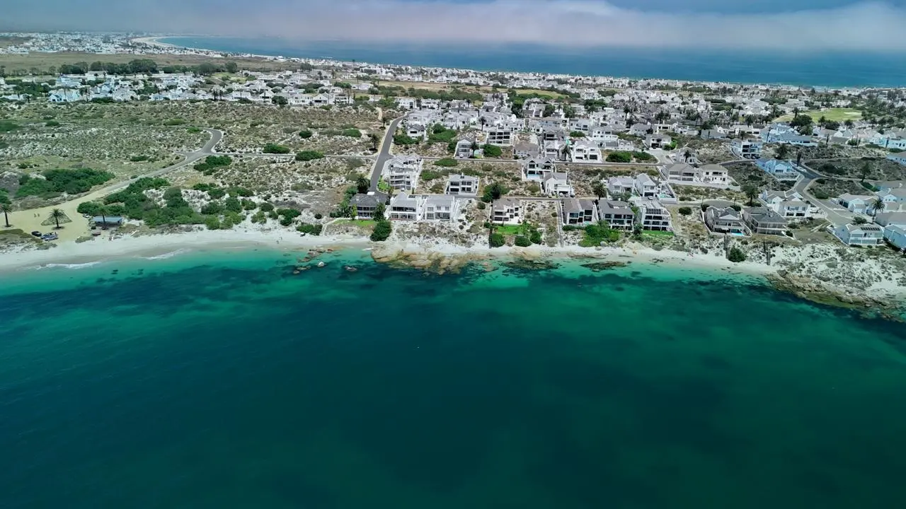 Aerial view of Shelley Point: white houses along the shore above the white beach and the turquoise water of the bay